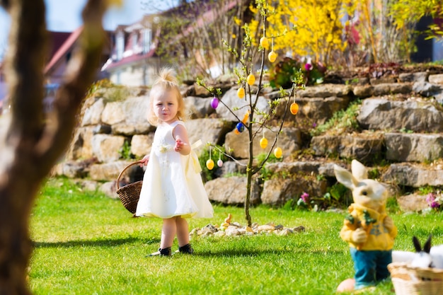 Ragazza sulla caccia dell'uovo di Pasqua Con le uova