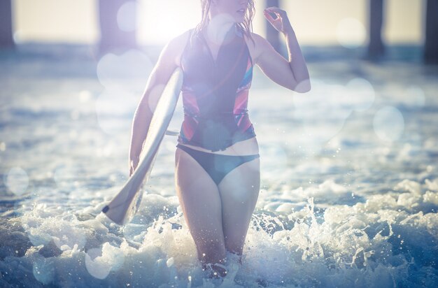 Ragazza surfista andando in acqua