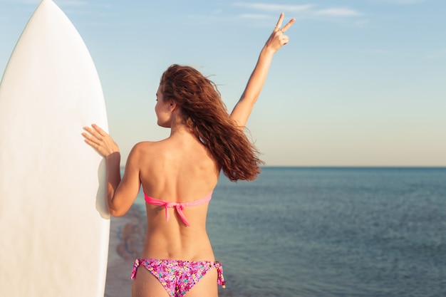 Ragazza surfista sulla spiaggia