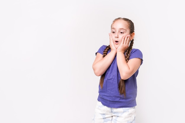 Ragazza Surorised bambino isolata su sfondo bianco. Bellissimo modello caucasico.