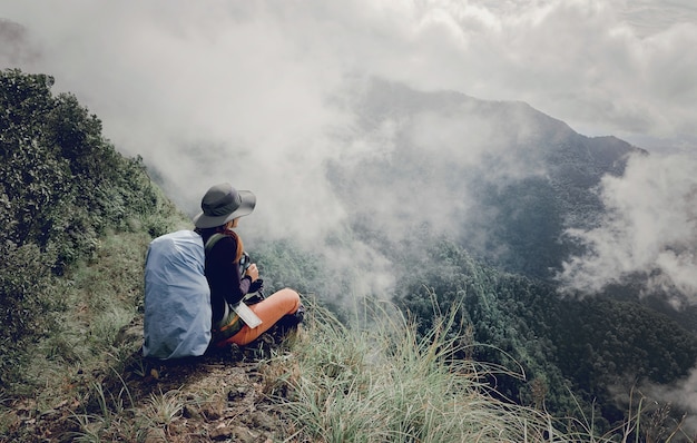 Ragazza sveglia che fa un&#39;escursione di giro scenico scenica su una montagna con l&#39;alta vista della nebbia bella