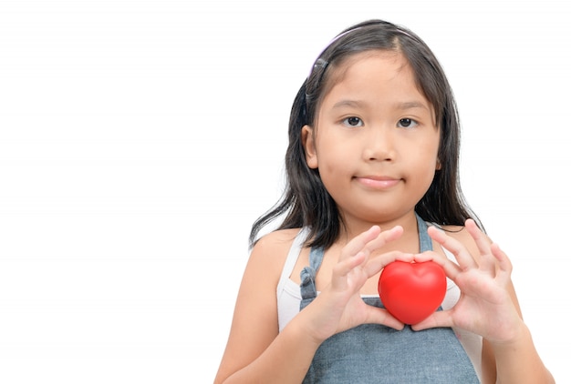 Ragazza sveglia che mostra una forma del cuore con le sue mani isolate