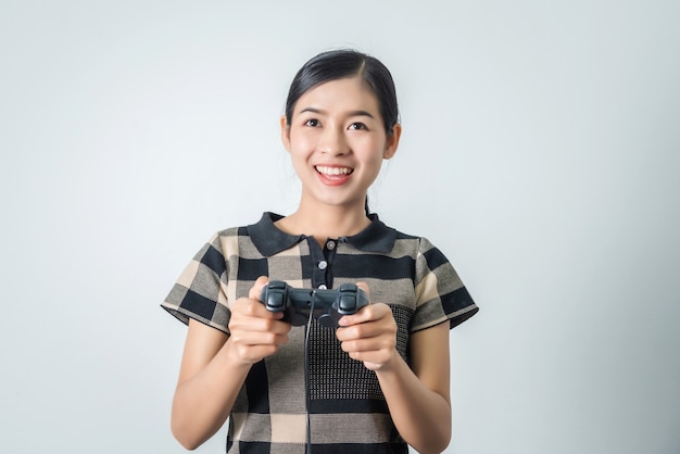 Ragazza tailandese asiatica che gioca video gioco con la leva di comando, donna di gioco felice.