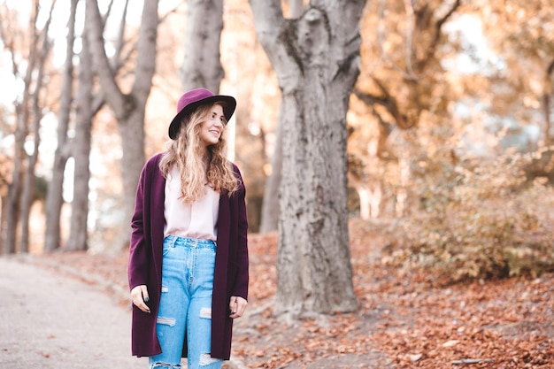 Ragazza teenager alla moda che indossa giacca e cappello alla moda che camminano nel parco