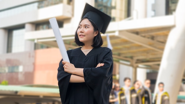 ragazza teenager asiatica con il panno dell&#39;abito di graduazione con sentirsi felice