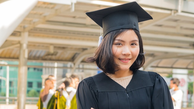 ragazza teenager asiatica con il panno dell&#39;abito di graduazione con sentirsi felice