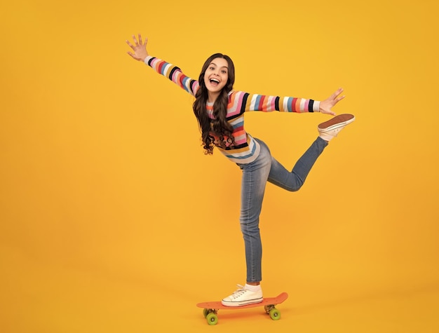 Ragazza teenager bella e alla moda che posa con lo skateboard Stile di vita della moda di strada dell'adolescente Adolescente felice emozioni positive e sorridenti della ragazza teenager