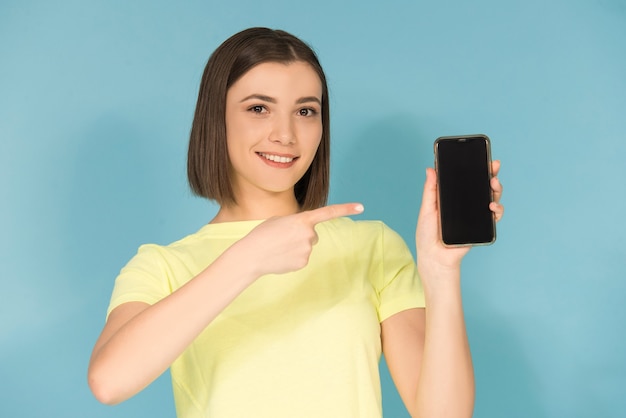 Ragazza teenager caucasica che tiene il cellulare