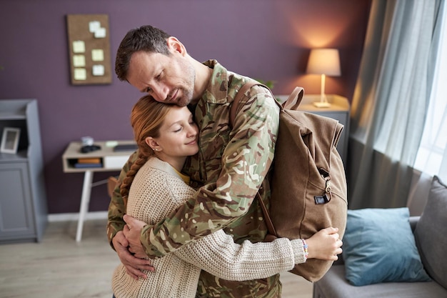 Ragazza teenager che abbraccia il padre militare che torna a casa dall'esercito