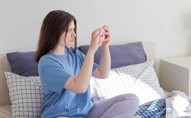 Ragazza teenager che cattura foto sul telefono sulla camera da letto