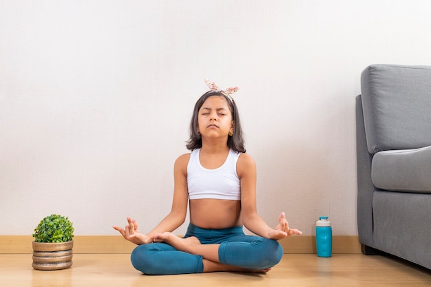 Ragazza teenager che fa yoga a casa