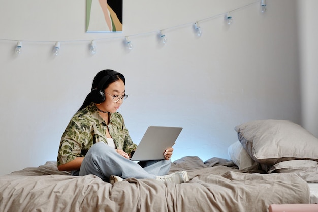 Ragazza teenager che per mezzo del computer portatile minimo