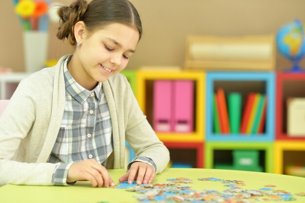 Ragazza teenager che raccoglie i pezzi del puzzle