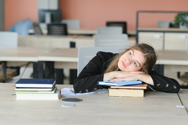 Ragazza teenager che studia con il saggio di scrittura del libro di testo che impara in aula