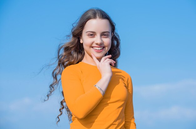 Ragazza teenager con viso affascinante sullo sfondo del cielo