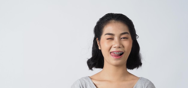 Ragazza teenager dell'apparecchio dentale che sorride alla ricerca su una macchina fotografica