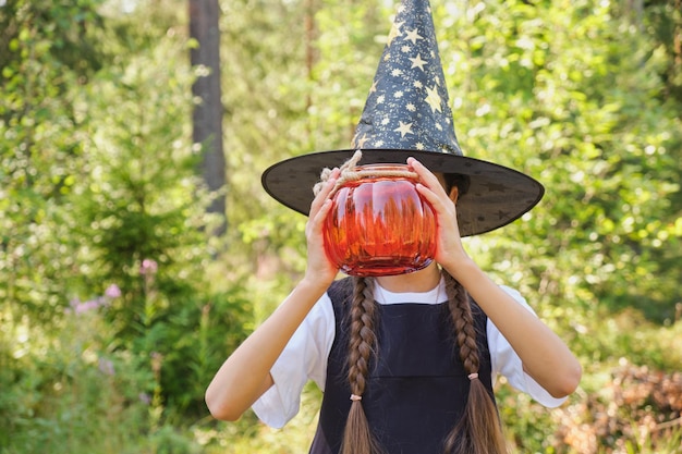 Ragazza teenager in un costume da strega nel parco