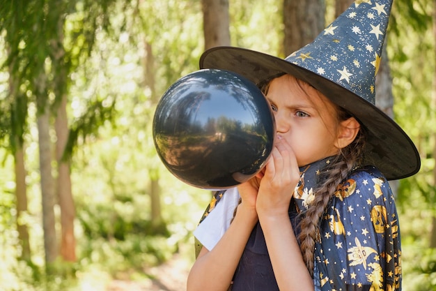 Ragazza teenager in un costume da strega nel parco