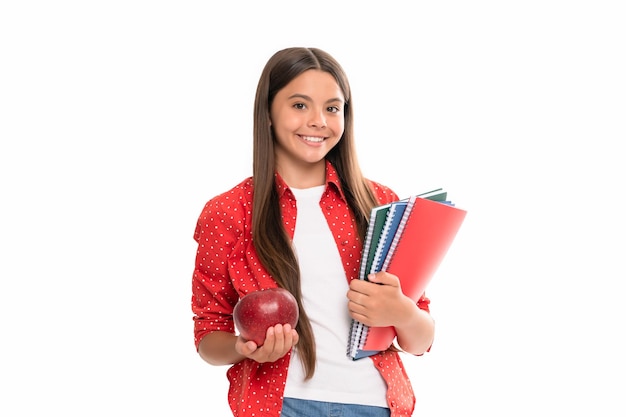 Ragazza teenager sorridente con il taccuino di nuovo al bambino della scuola con la mela pronta per studiare