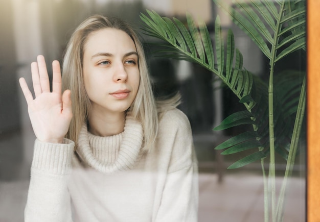 Ragazza triste vicino alla finestra che pensa a qualcosa