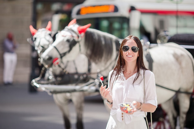 Ragazza turistica che gode della vacanza a Vienna e che esamina i bei cavalli nel trasporto