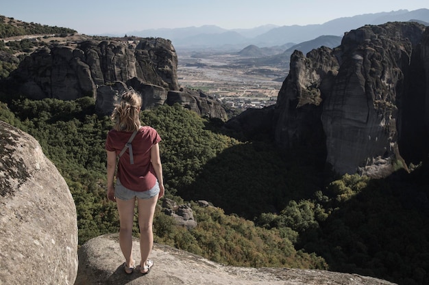 Ragazza turistica che gode della vista della città di Kalabaka dal monastero miracoloso sulla formazione rocciosa Meteora Grecia