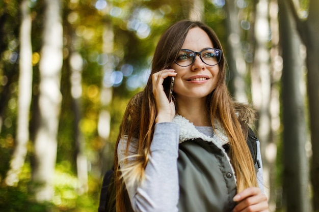 Ragazza turistica nella foresta con lo smartphone