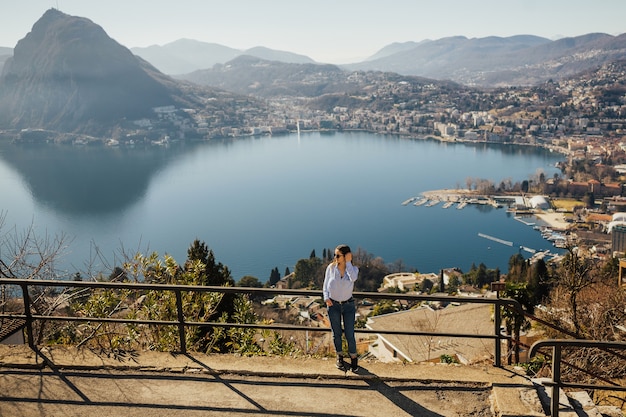 Ragazza turistica sul lago di Lugano in Svizzera guardando il panorama.