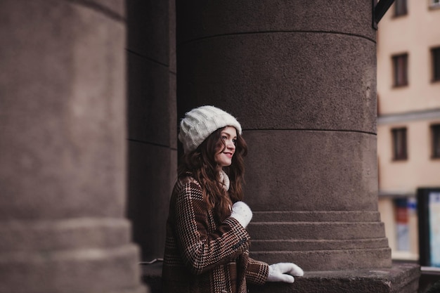 Ragazza vestita con un cappotto a quadri e un cappello invernale