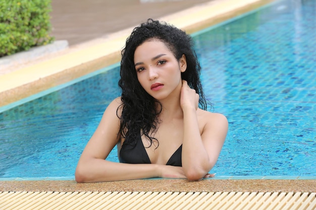 Ragazza vestita in bikini a bordo piscina Attraente giovane donna in bikini rilassarsi in piscina