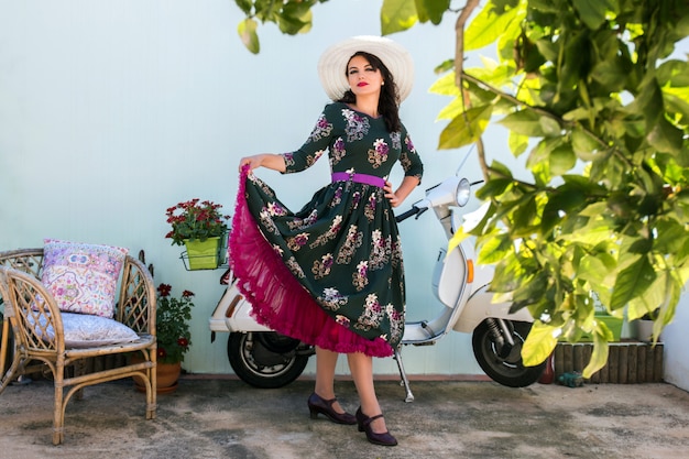 Ragazza vintage accanto alla moto