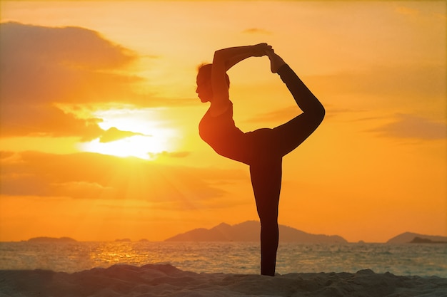 Ragazza yoga sulla spiaggia