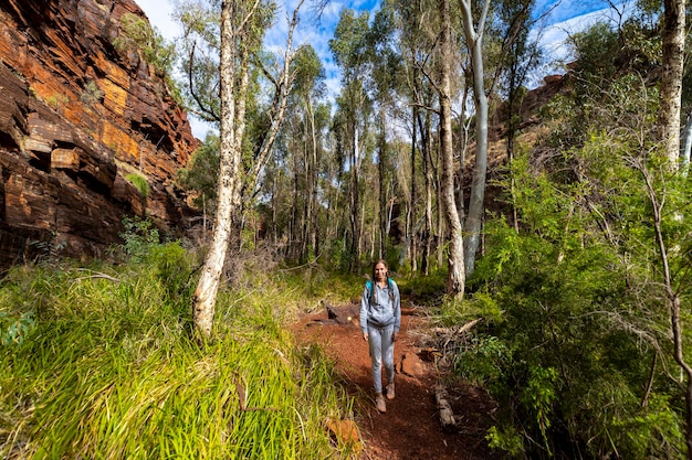 ragazza zaino in spalla che fa un'escursione attraverso un canyon nel parco nazionale di karijini nell'australia occidentale