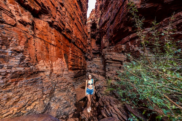 ragazza zaino in spalla che fa un'escursione in un canyon molto stretto nel parco nazionale di karijini nell'australia occidentale