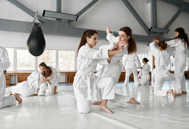 Ragazze adolescenti che combattono all'addestramento di aikido nella scuola di arti marziali