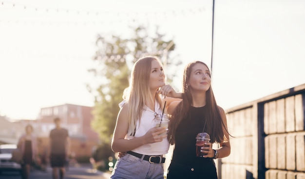 ragazze alla moda che abbracciano sulla strada in città