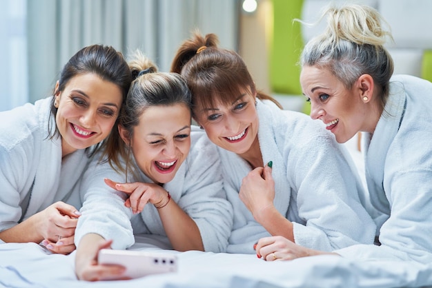 Ragazze alla spa party in hotel con il telefono