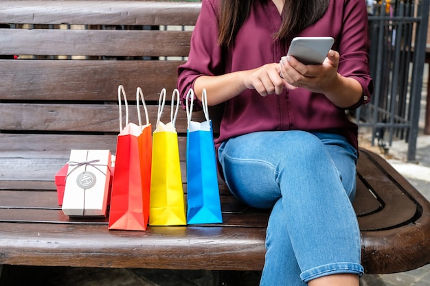 Ragazze asiatiche che tengono i sacchetti della spesa di vendita. concetto di stile di vita del consumismo nel centro commerciale.