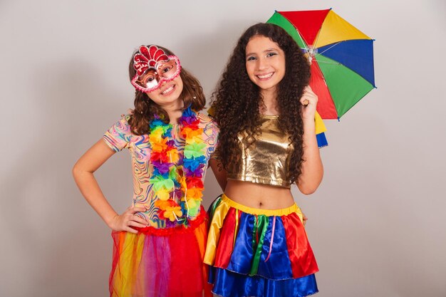 Ragazze brasiliane amiche vestite con abiti di carnevale che si abbracciano