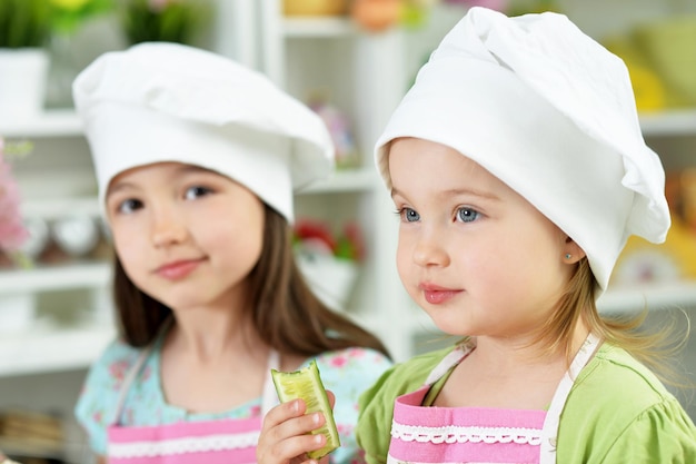 Ragazze carine con cetriolo in cucina