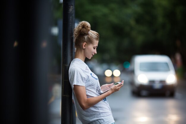 Ragazze carine con tablet alla fermata dell'autobus