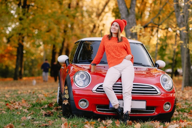 Ragazze che camminano nel parco autunnale nel concetto di umore autunnale di auto rossa