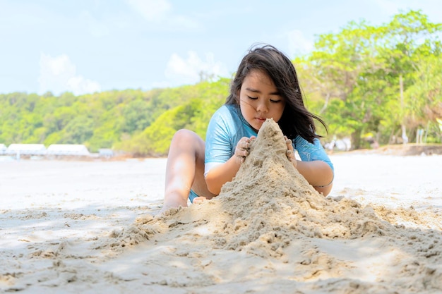 Ragazze che giocano felicemente sulle dune di sabbia in riva al mare Si è sentita libera di imparare e giocare con esso Bellissimo mare a Rayong Thailandia