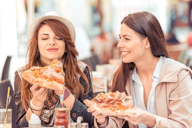 Ragazze che mangiano pizza in mensa