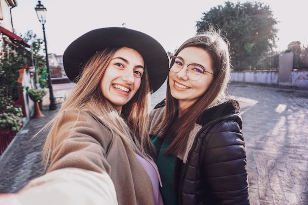 Ragazze che prendono selfie in strada - concetto di amicizia