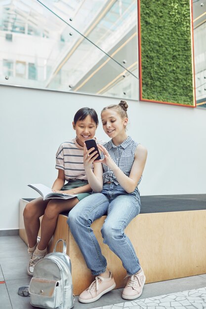 Ragazze che usano lo smartphone a scuola