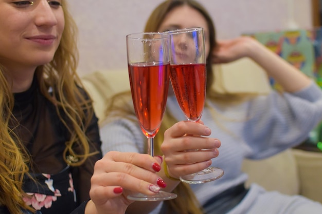 Ragazze con gli occhiali a una festa sul divano di casa.