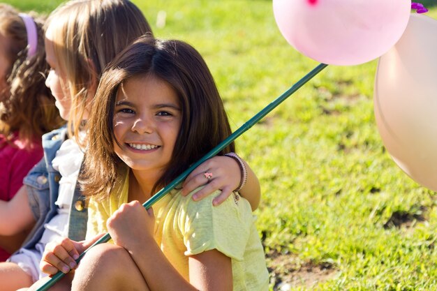 Ragazze con palloncini, seduta sull&#39;erba