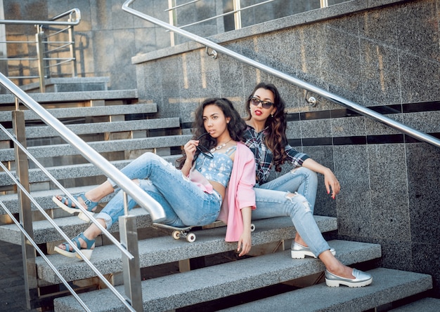 Ragazze con skateboard seduto sulle scale