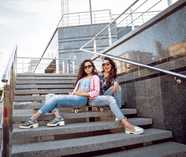 Ragazze con skateboard seduto sulle scale